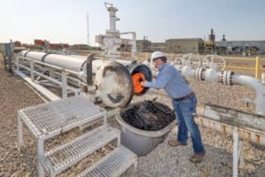 WeldFit technicians loading SureLaunch pigs into an automated pigging system